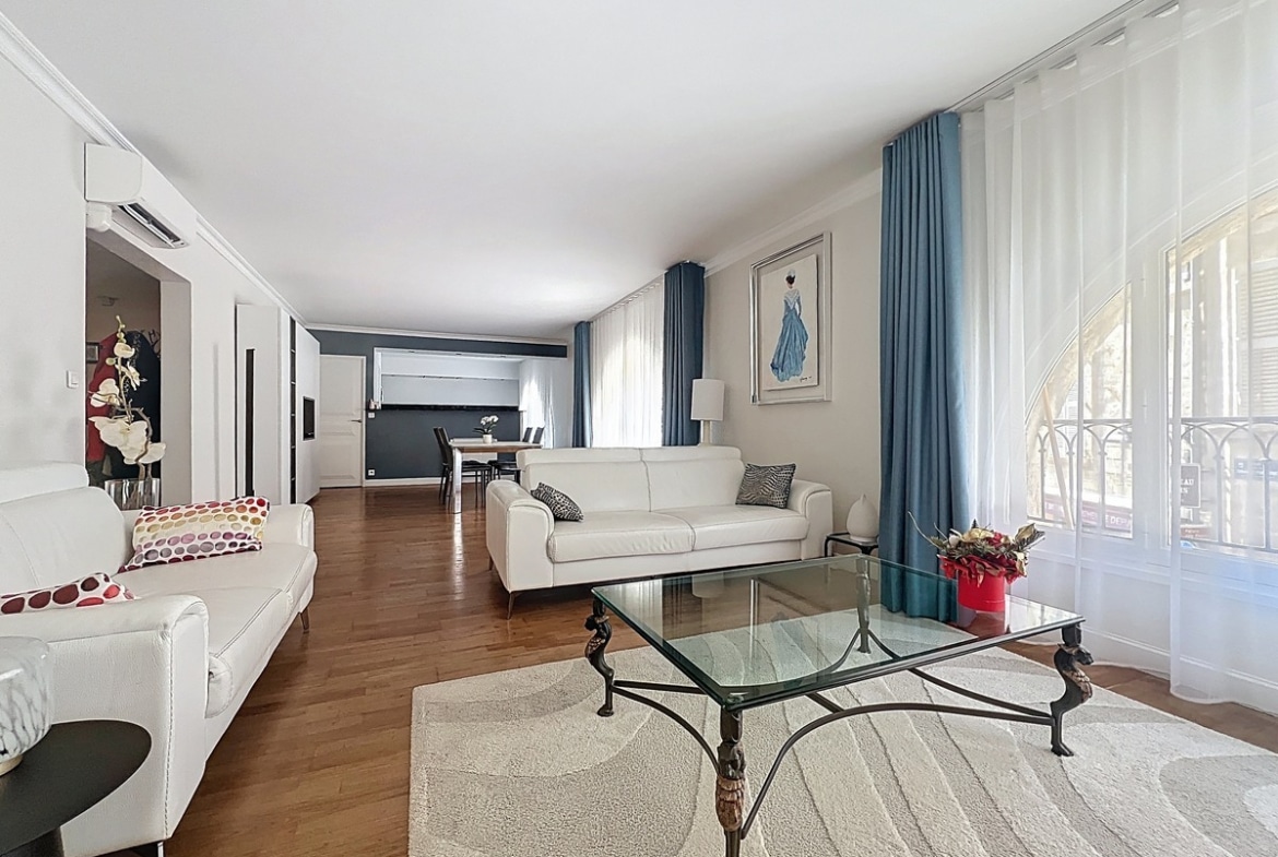 Séjour ouvert avec espace repas et accès vers la cuisine américaine. Sol uniforme et plafond avec hauteur standard dans ce duplex avignonnais.