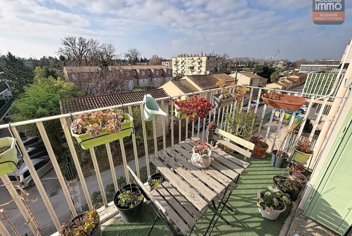 Balcon avec garde-corps métallique et sol carrelé, accessible par une porte-fenêtre à double vitrage. Vue dégagée sur la résidence et les espaces verts du secteur ceinture verte.