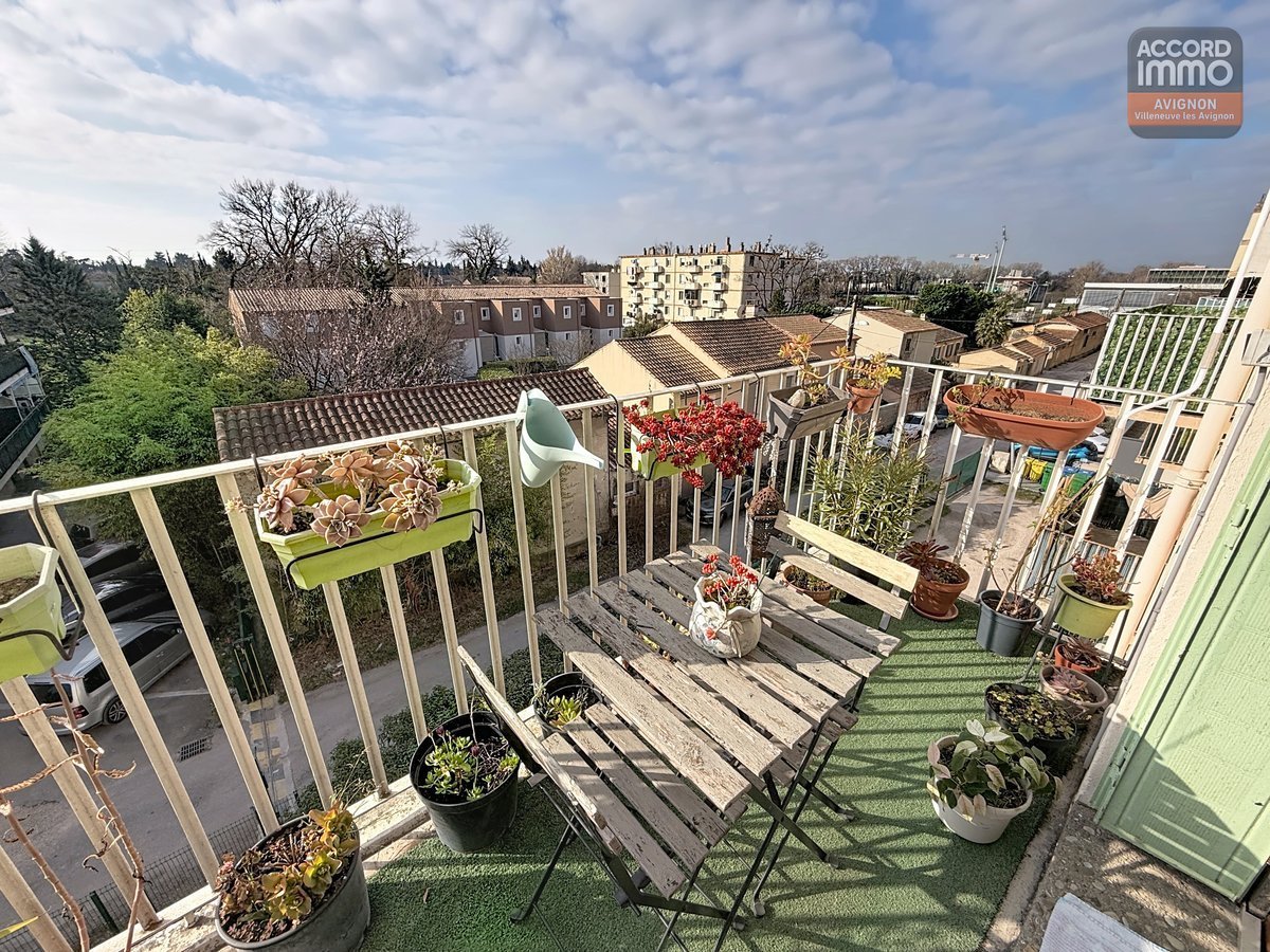 Balcon avec garde-corps métallique et sol carrelé, accessible par une porte-fenêtre à double vitrage. Vue dégagée sur la résidence et les espaces verts du secteur ceinture verte.