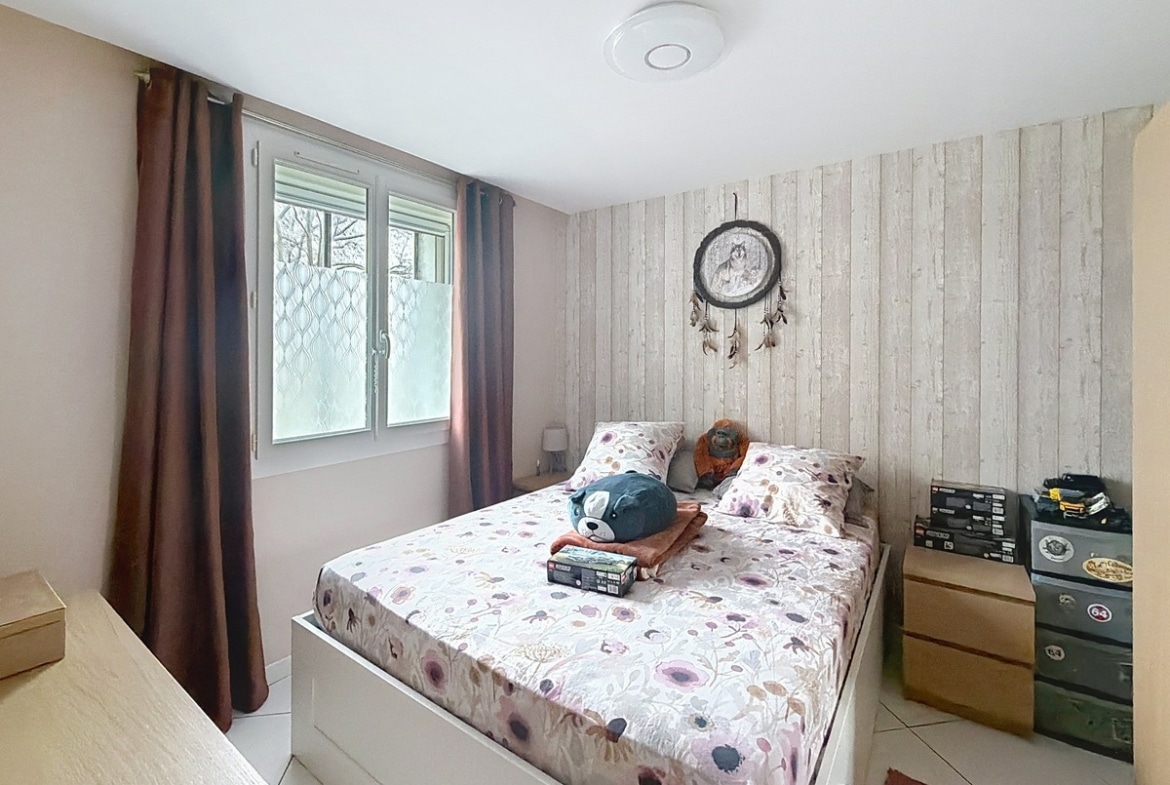 Chambre avec murs clairs et fenêtre apportant la lumière naturelle. Espace aménageable avec placard de rangement intégré.