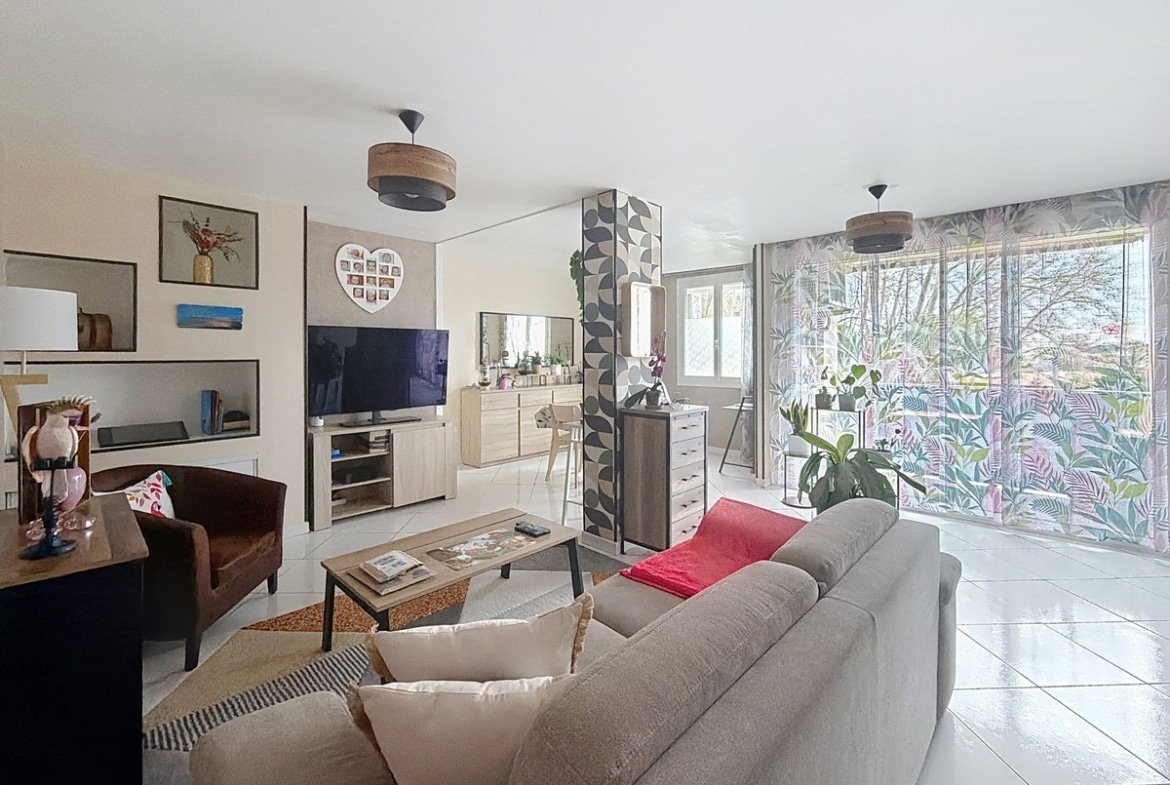 grand séjour donnat sur balcon, espace salon avec canapé clair et table basse