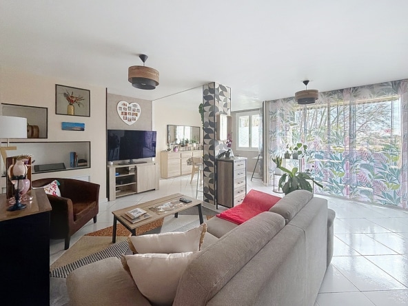 grand séjour donnat sur balcon, espace salon avec canapé clair et table basse