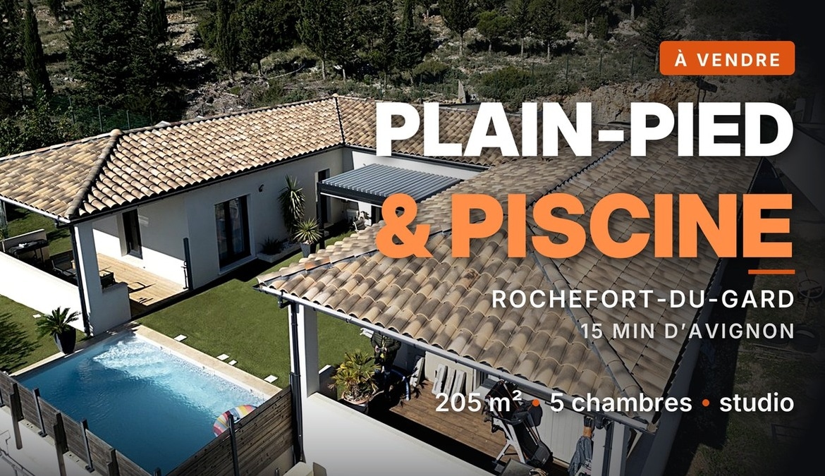 Vue aérienne d'une maison plain-pied à toiture en tuiles canal, avec piscine rectangulaire carrelée et terrasse en bois, à Rochefort-du-Gard.