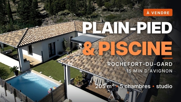 Vue aérienne d'une maison plain-pied à toiture en tuiles canal, avec piscine rectangulaire carrelée et terrasse en bois, à Rochefort-du-Gard.