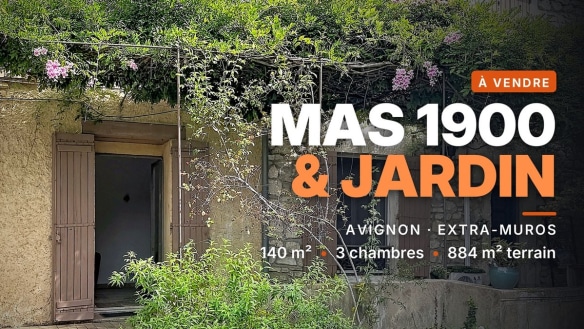 Façade en pierre d'un mas en vente à Avignon, couverte de glycine et bougainvillier en fleurs, avec une porte entrouverte et une végétation dense au premier plan.